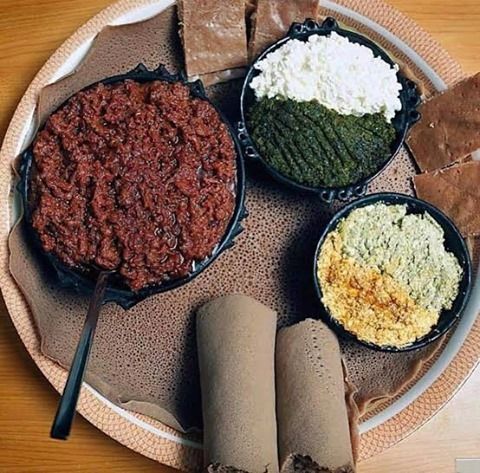 Ethiopian Kitfo - spice-marinated raw beef with extra spice, sides, and injera bread rolls